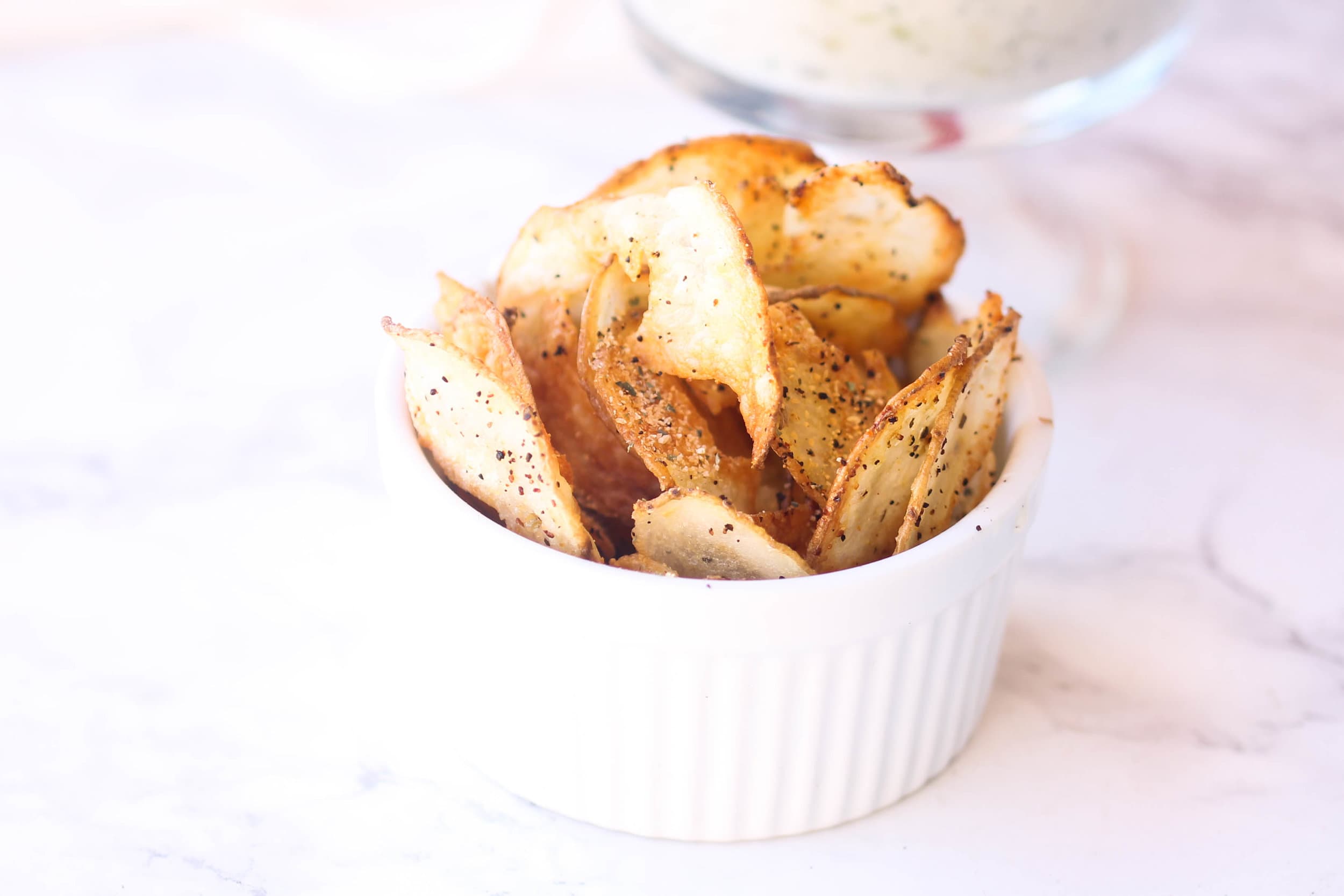 Golden potato chips piled in a serving dish.